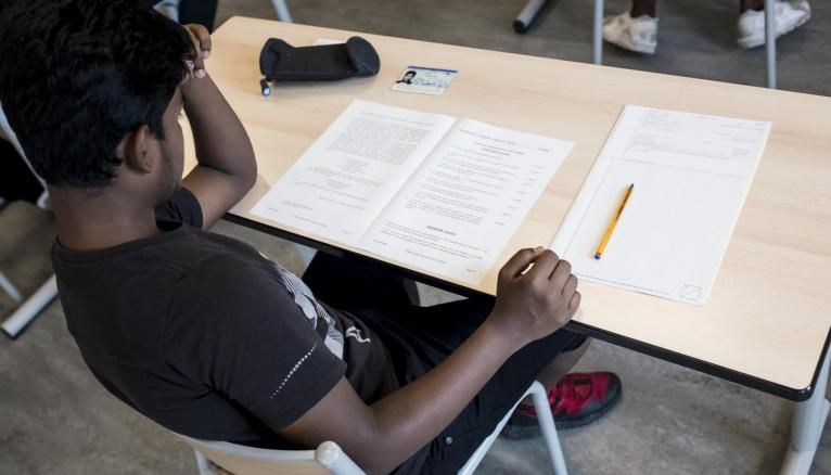 Un élève lit le sujet de français lors d'une épreuve du DNB au collège Aime Cesaire dans le 18e arrondissement de Paris.