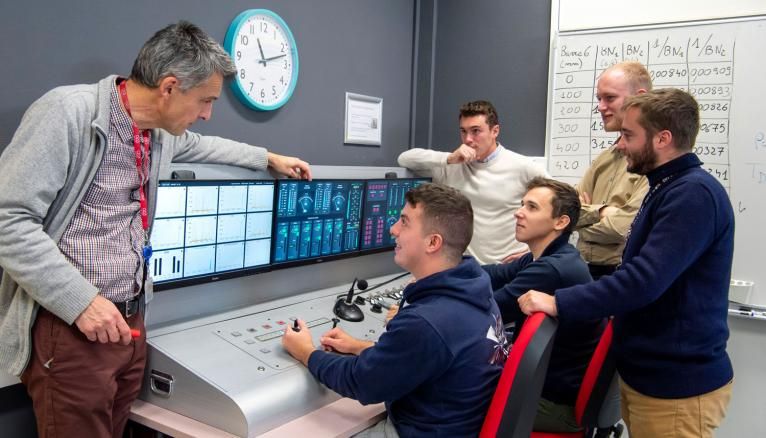 Etudiants de la formation initiale génie atomique en travaux pratiques sur le pupitre de pilotage de réacteur nucléaire de la plateforme Evoc de l’INSTN Saclay.