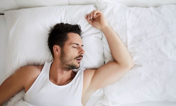 Un homme dort profondément dans son lit