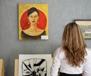 Une femme regarde des tableaux dans un musée