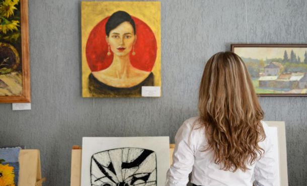 Une femme regarde des tableaux dans un musée