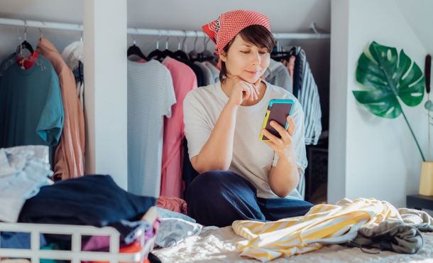 Une femme prend des vêtements en photo pour les mettre en vente