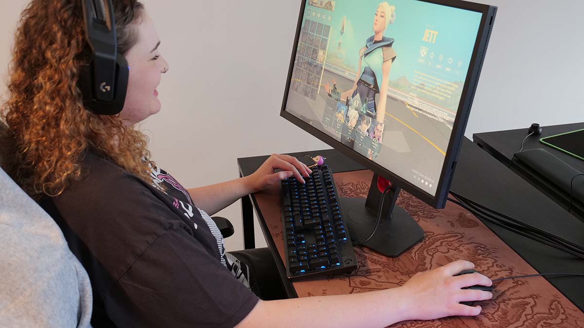 Etudiante heureuse devant son ordinateur sur une partie de Valorant				